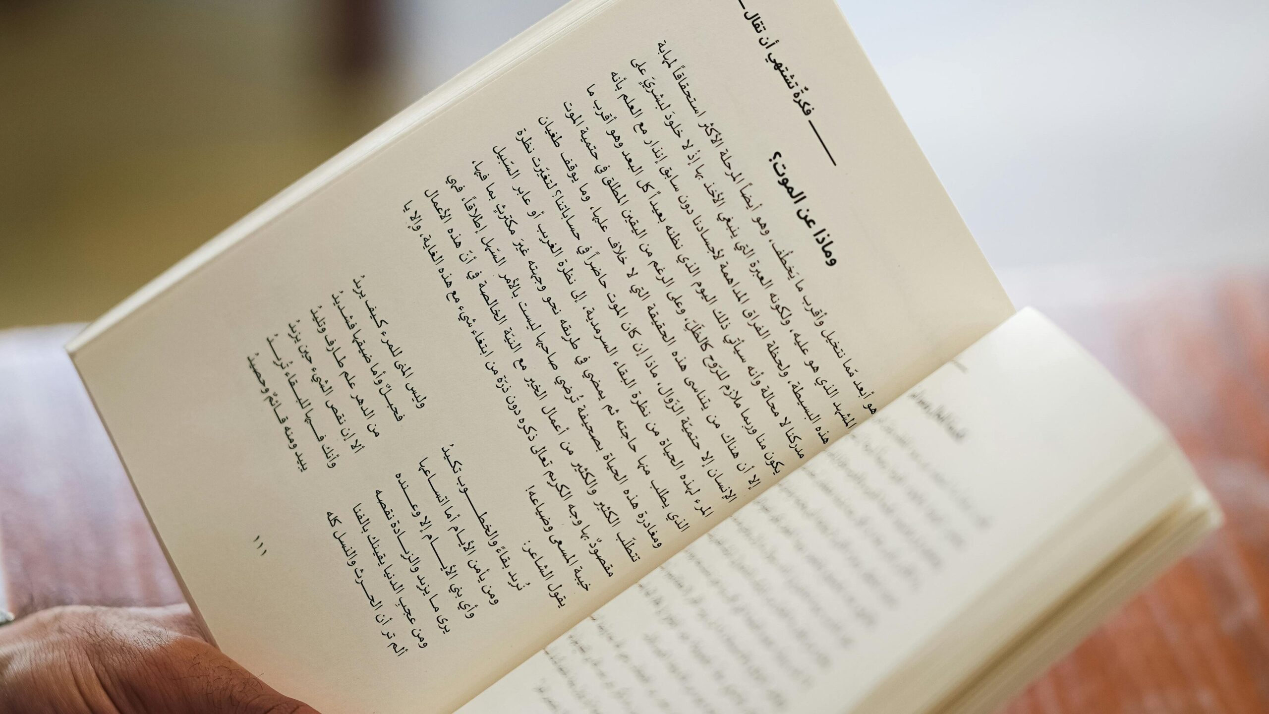 pexels photo 32821858 32821858 Close-up of a person reading an Arabic book indoors. Focus on hands and text.